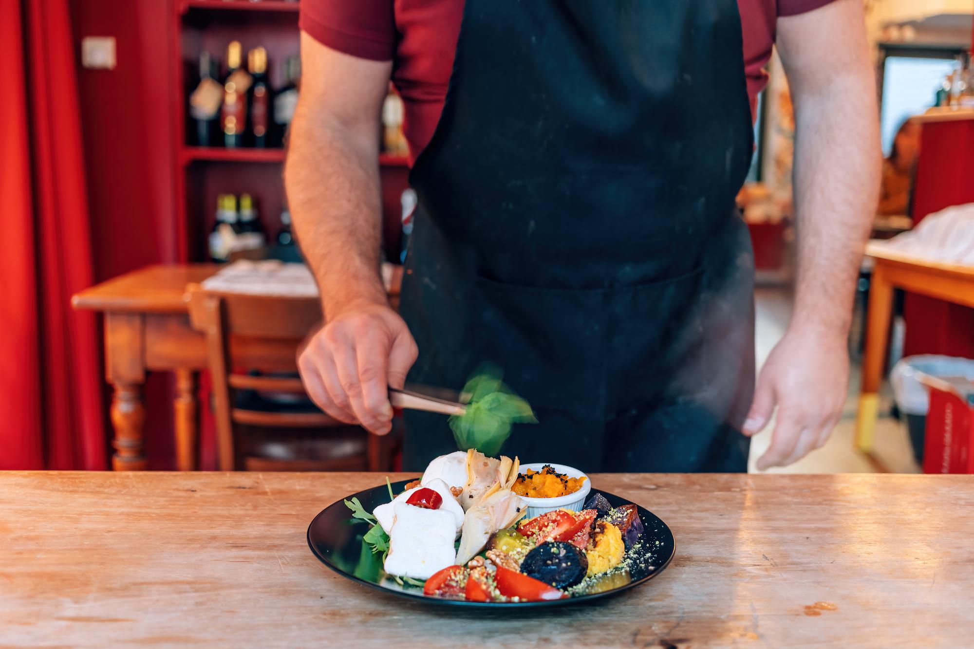 Chefas demonstruoja kepamą patiekalą ant stalo